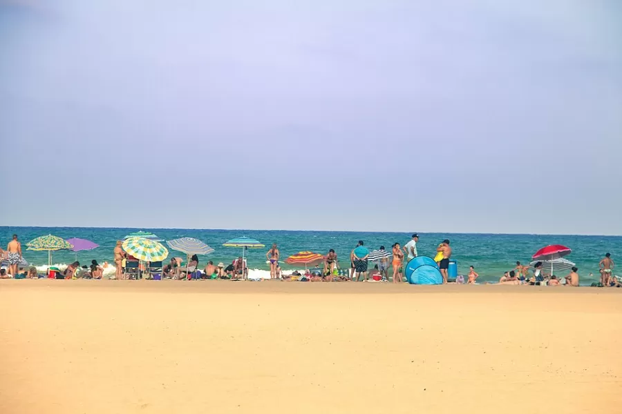 Sunshades and swimmers on Malvarrosa beach in Valencia